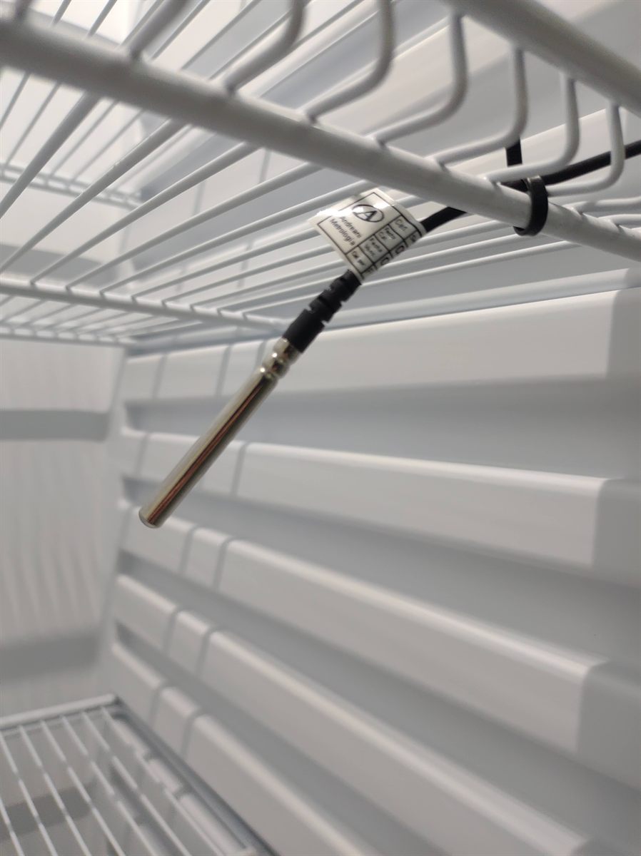 Sensor NTC de acero inoxidable con etiqueta de calibración Andreani Metrología dentro de una heladera
