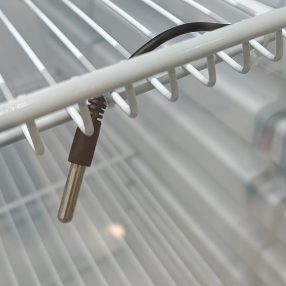 Primer plano del sensor de temperatura tipo NTC instalado dentro de una heladera de medicamentos
